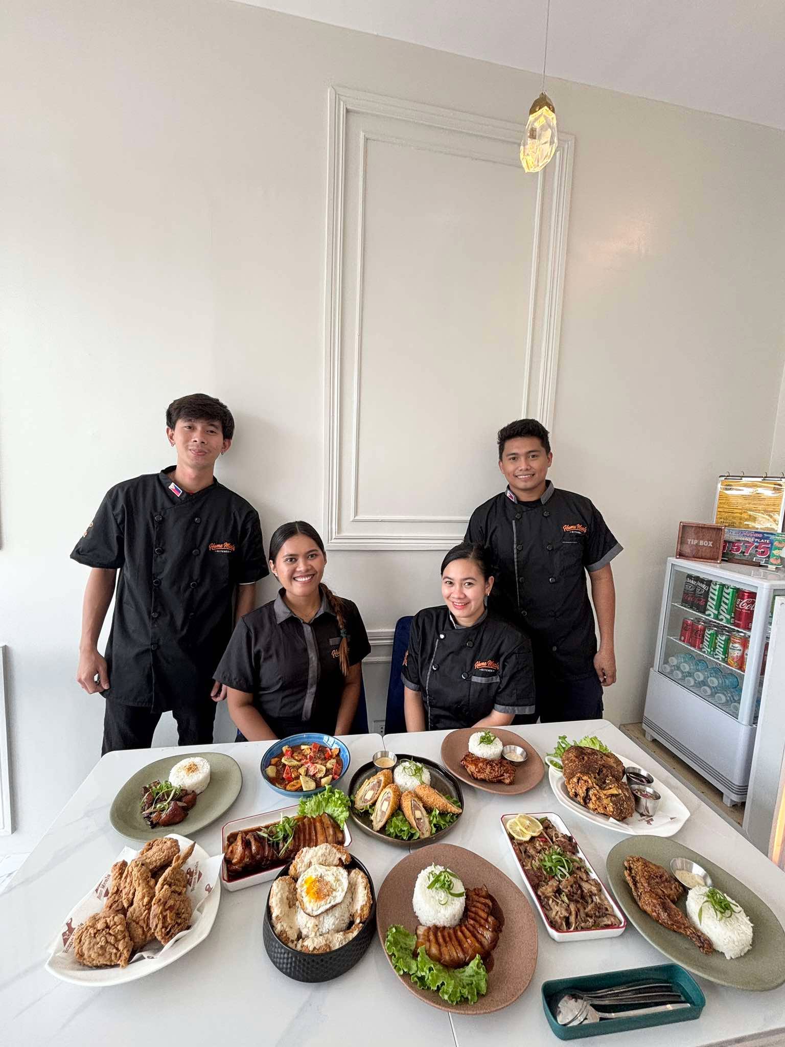 The Home Meals Kitchen team in the dining room behind a spread of house dishes